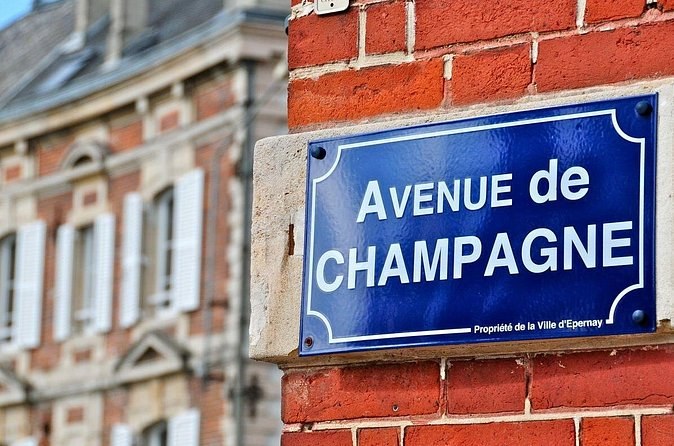 The Avenue de Champagne street sign on a brick house front