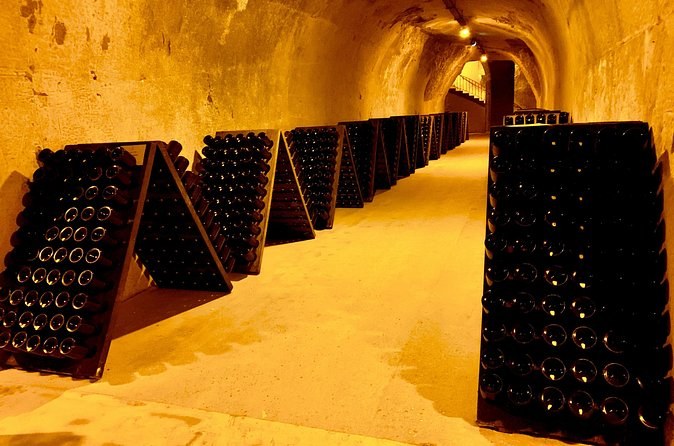 Riddling racks of bottles lining a lit chalk tunnel